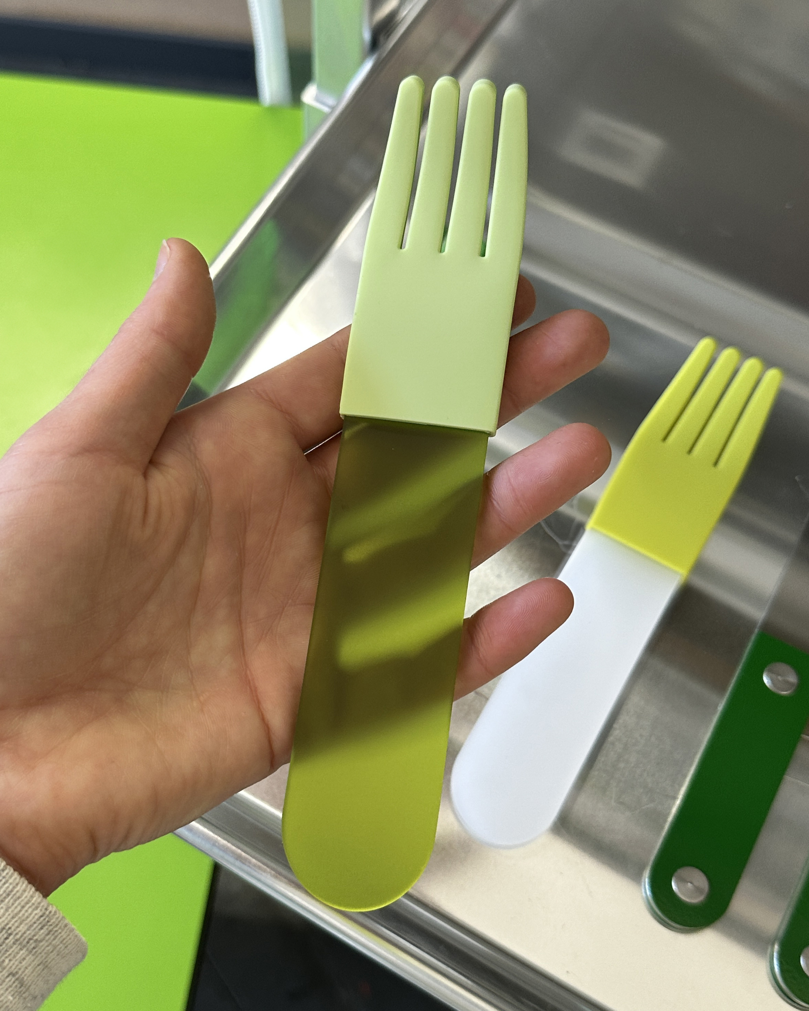 forks-plus-hand-holding-green-acrylic-fork-light-green-sleeve Hand holding green transparent acrylic fork with light green silicone sleeve
