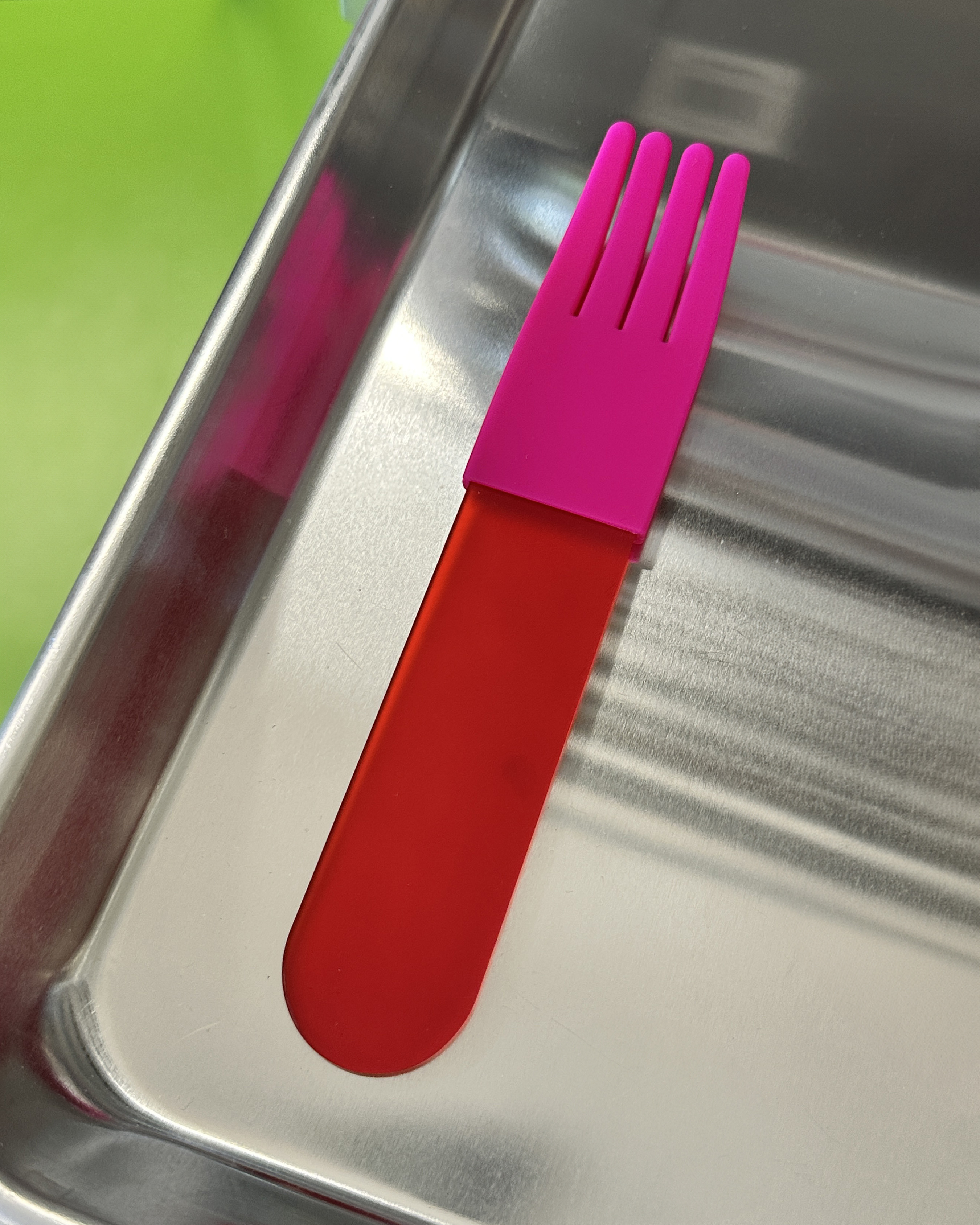 forks-plus-red-fork-pink-sleeve-stainless-steel-tray Red acrylic fork with a pink silicone sleeve sitting on stainless steel tray