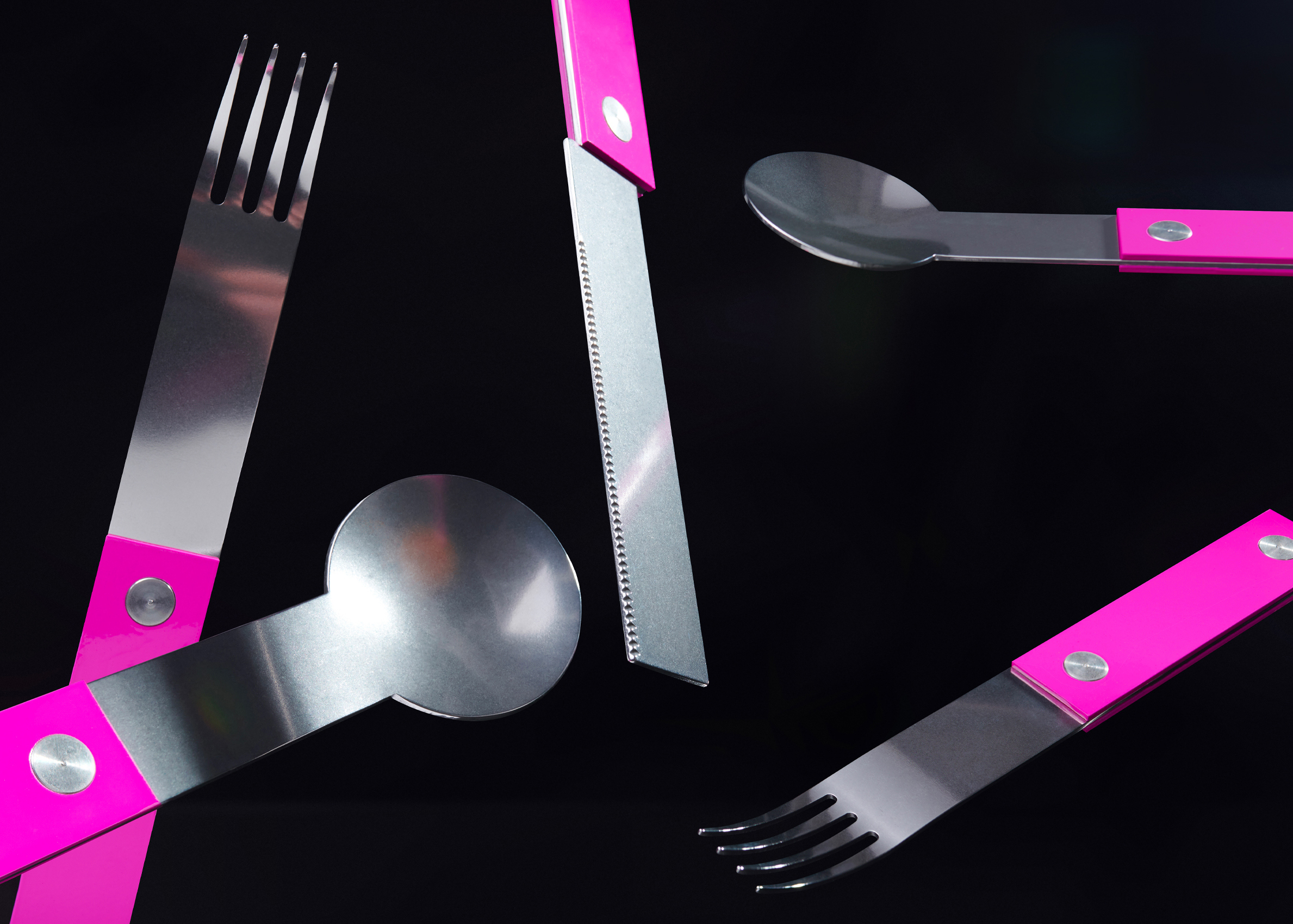 forks-plus-flatware-pink-handles-black-background 5 piece pink-handled flatware set on black surface arranged at mixed angles