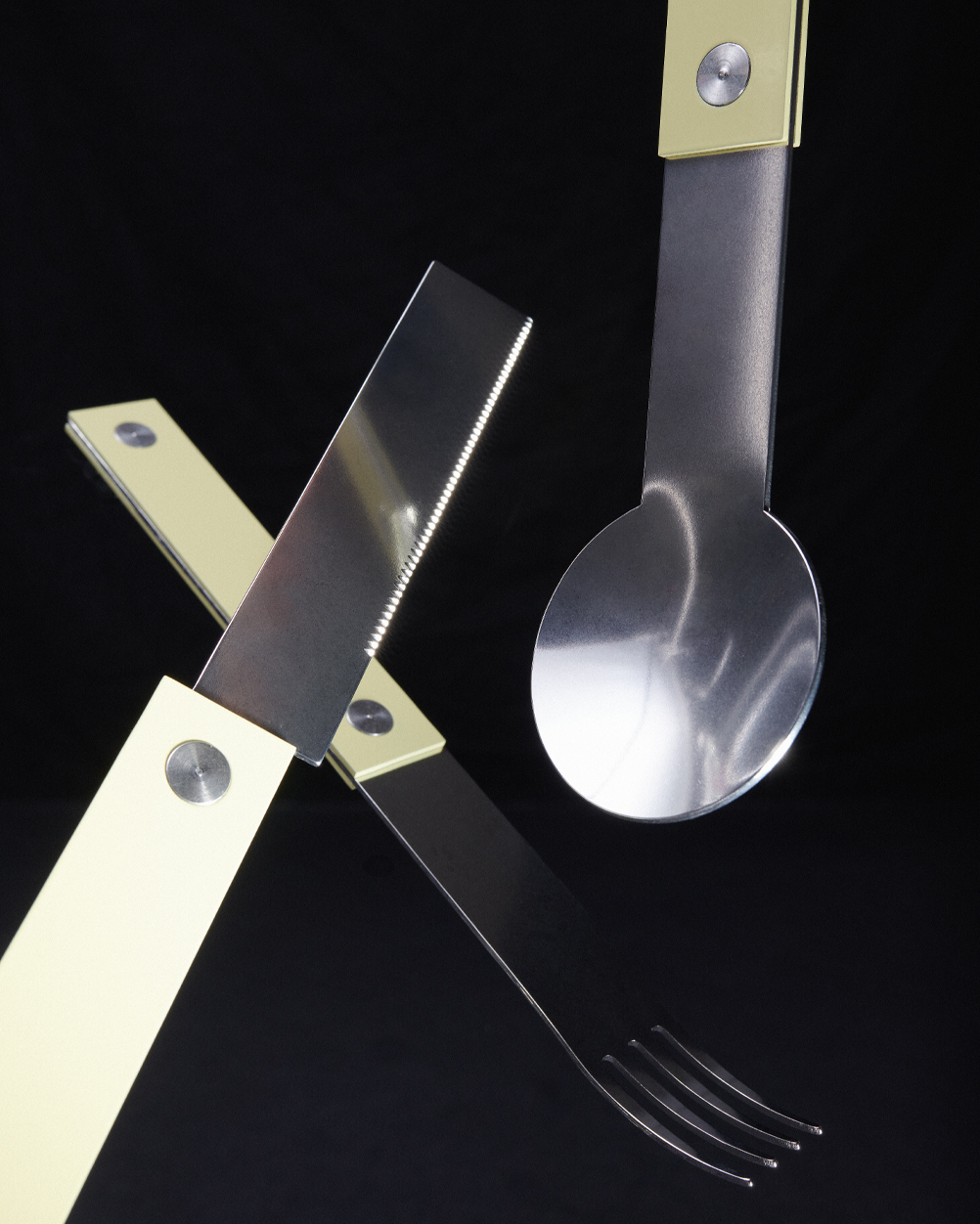forks-plus-flatware-trio-butter-handles-black-background Trio of flatware with butter-colored handles on black background